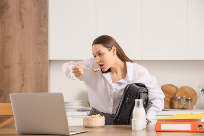 Hurrying,Young,Businesswoman,Talking,By,Mobile,Phone,While,Having,Breakfast